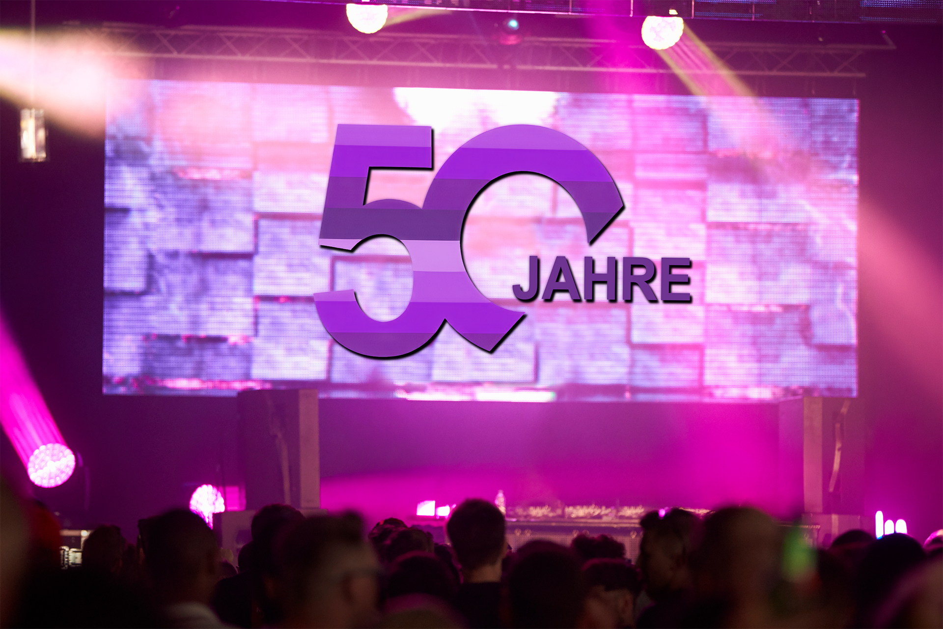 Filmischer Rückblick auf einer Firmenfeier zum 50-jährigen Jubiläum: Großleinwand mit dem Schriftzug ‚50 Jahre' über dem Publikum