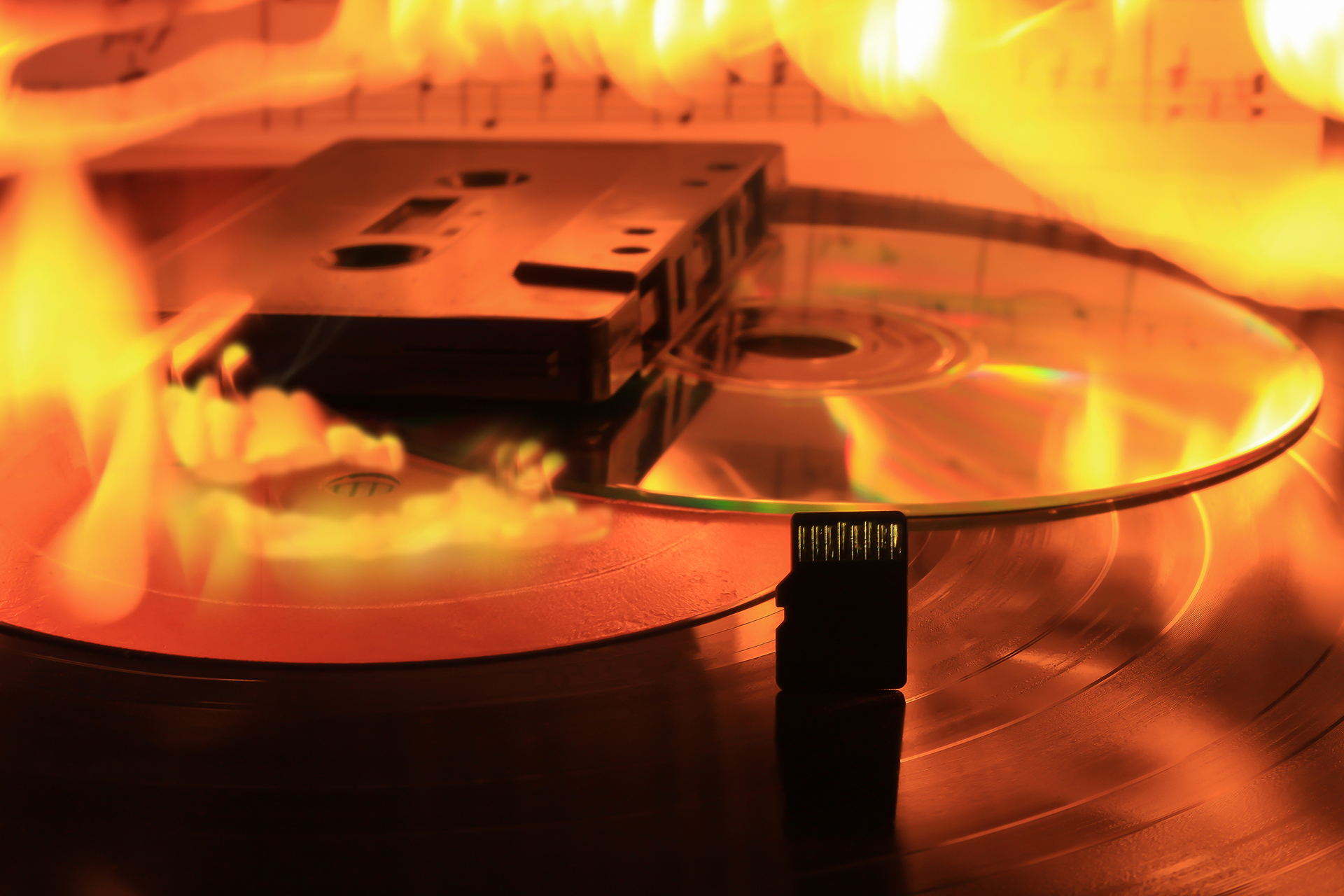 Audiokassette, CD und Schallplatte in Flammen